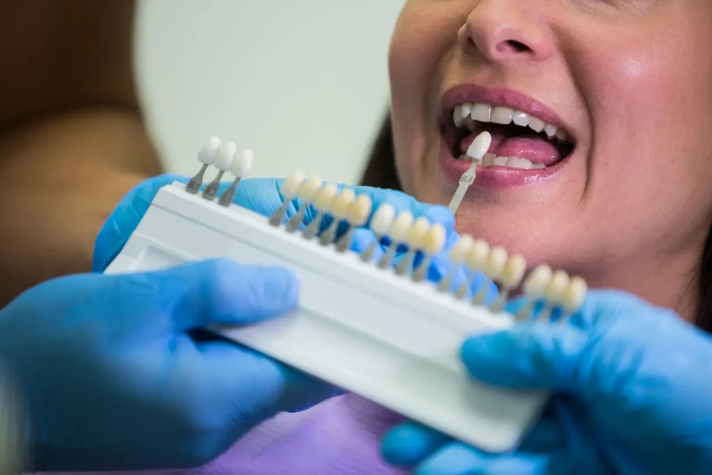 Dentist at Family Dental Group matching tooth shade for same-day crowns with a female patient.