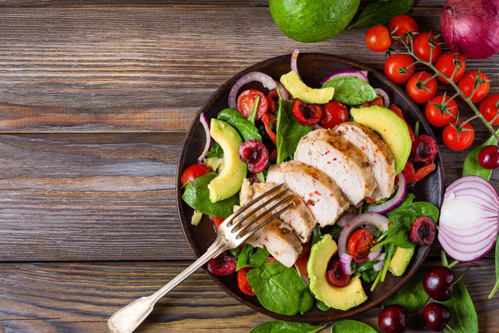 Healthy salad with avocado, cherry tomatoes, and grilled chicken, emphasizing the connection between heart health and proper nutrition, as promoted by Family Dental Group alongside brushing for comprehensive wellness.