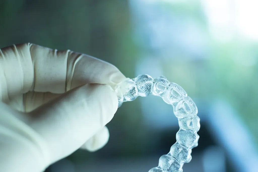 Close-up of a gloved hand holding ClearCorrect Aligners, illustrating the advanced orthodontic solution provided by Family Dental Group in Missoula, MT.