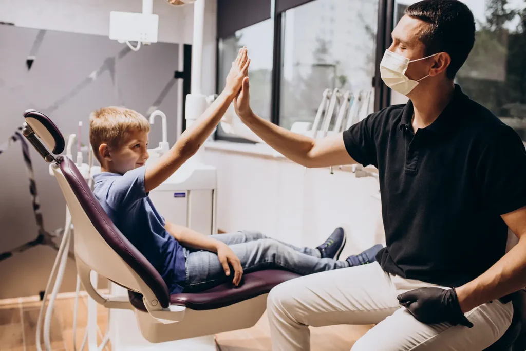 Young boy receiving preventative dental care, celebrating a successful dental visit at Family Dental Group, highlighting the importance of dental hygiene.